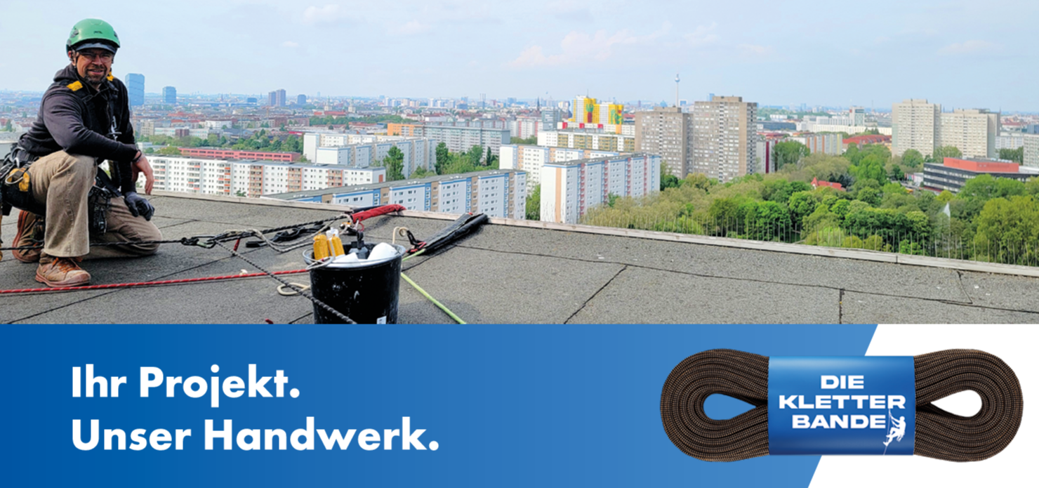 Industriekletterer auf Dach mit Stadtblick